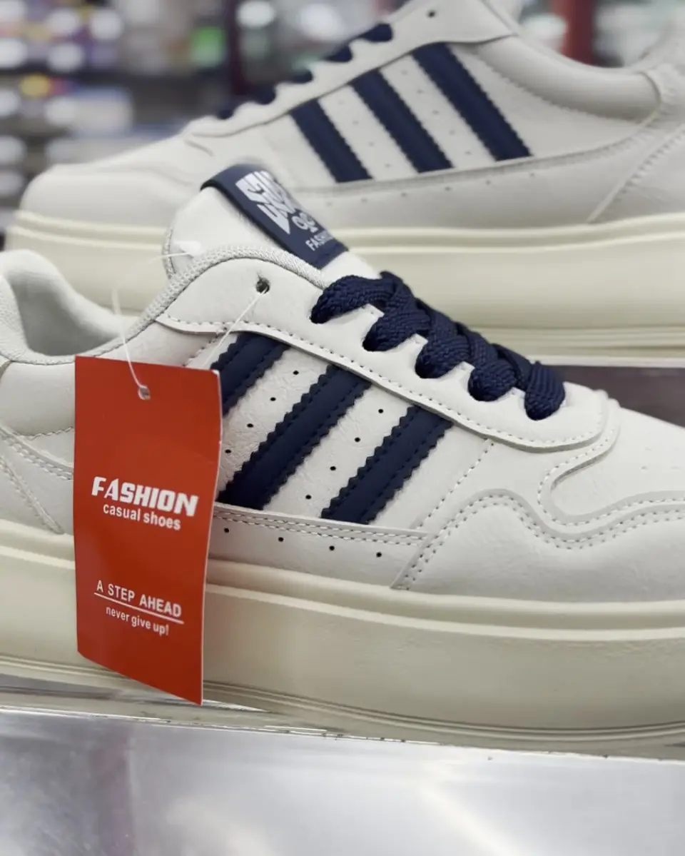 White sneakers with navy stripes on display